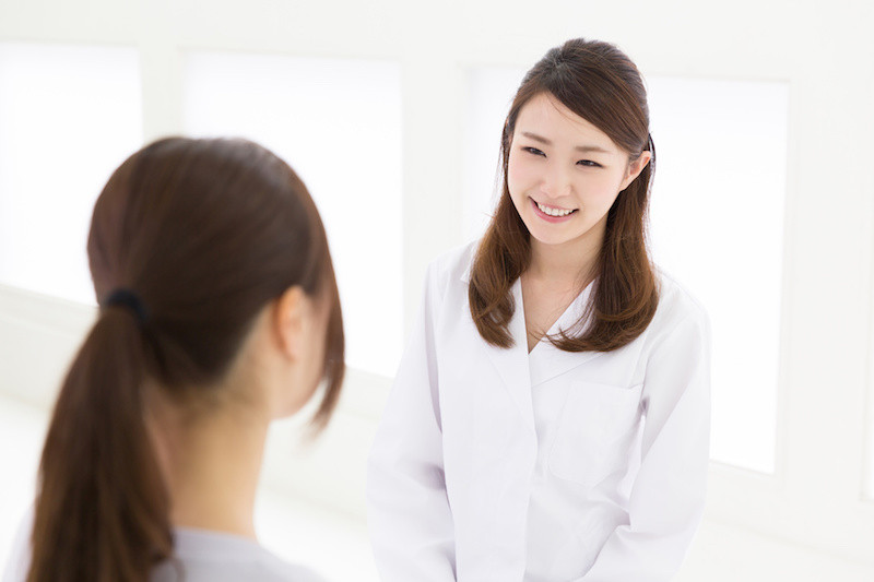 女性に微笑みかける白衣の女性